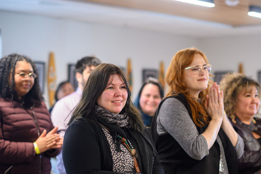 Attendees of the signing react once it is completed on Friday, March 27, 2026. (Jasz Garrett / Juneau Independent)
