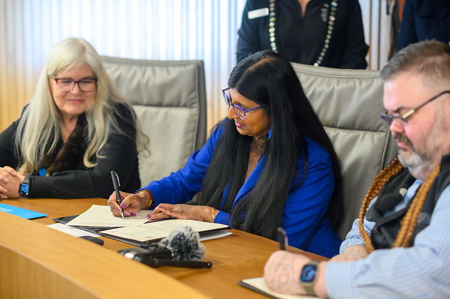 University of Alaska Southeast Chancellor Aparna Palmer and Chalyee Éesh Richard Peterson, president of the Central Council of the Tlingit and Haida Indian Tribes of Alaska, sign a memorandum of understanding to formalize the process of developing a School of Indigenous Studies on Friday, March 27, 2026. (Jasz Garrett / Juneau Independent)