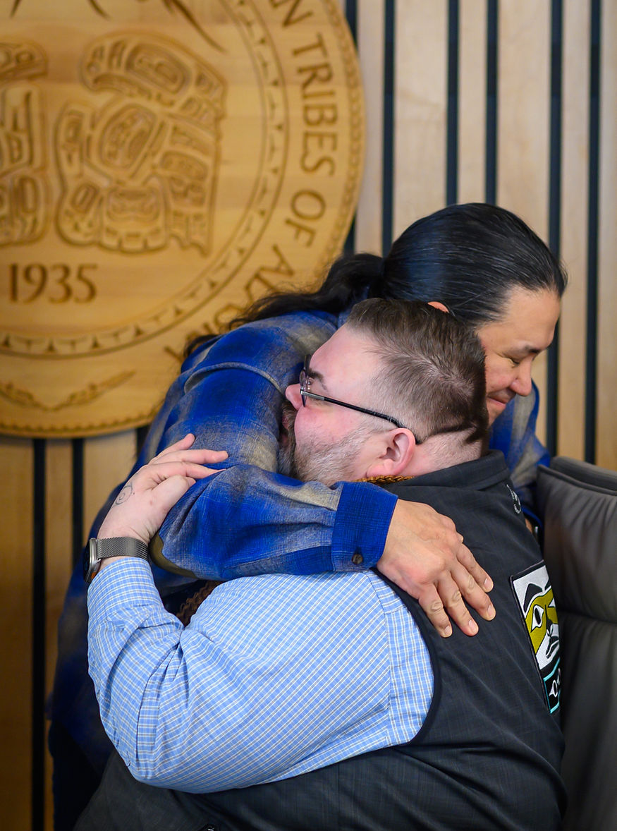 After the signing, Chalyee Éesh Richard Peterson, president of the Central Council of the Tlingit and Haida Indian Tribes of Alaska, hugs X̱’unei Lance Twitchell, a professor of Alaska Native Languages at UAS, on Friday, March 27, 2026. (Jasz Garrett / Juneau Independent)